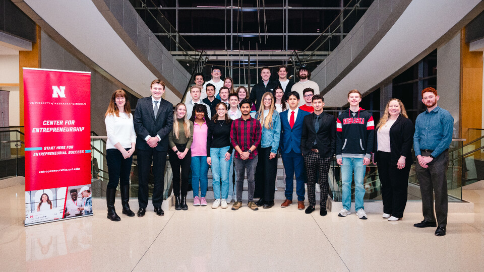About 20 students pose for a photograph on the main staircase of Howard L. Hawks Hall.