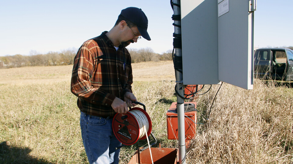 Aaron Young, a survey geologist with the Conservation and Survey Division, performs maintenance on a water well.