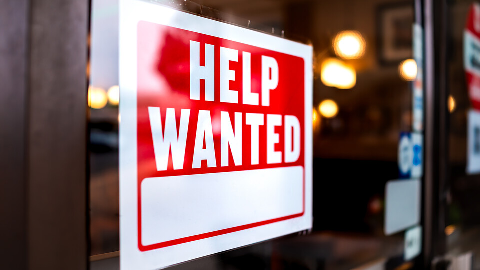 A "help wanted" sign on a window