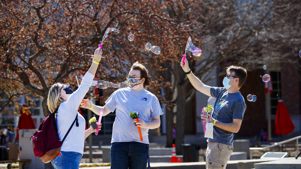 Samantha Moore, William Roarty and Jace Armstrong let the wind do the work as they blow bubbles outside the Nebraska Union. Students have fun at the Spring Breakout, a midday festival with free games, music, and prizes.