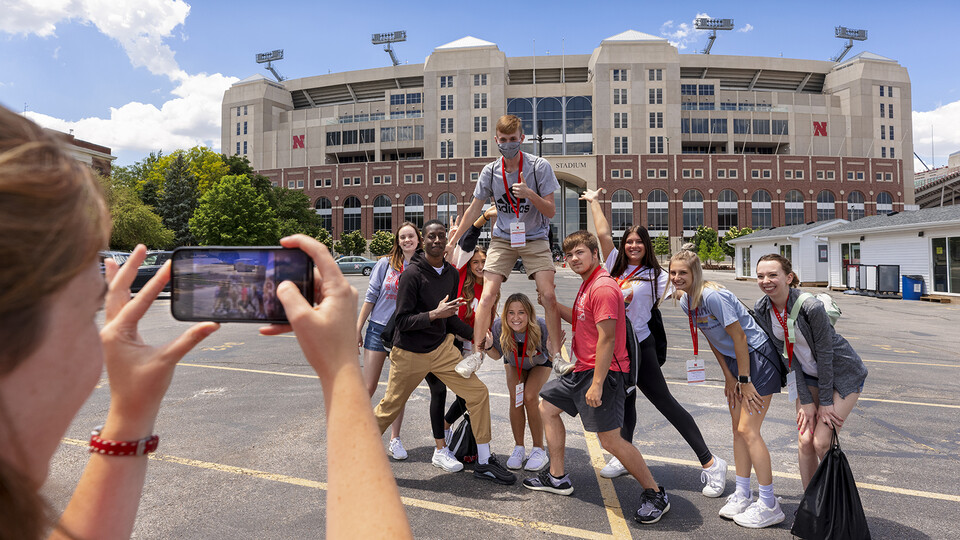 Gracie Williams, a New Student Enrollment orientation leader, takes her group’s photo outside of Memorial Stadium as they toured campus on June 2. 