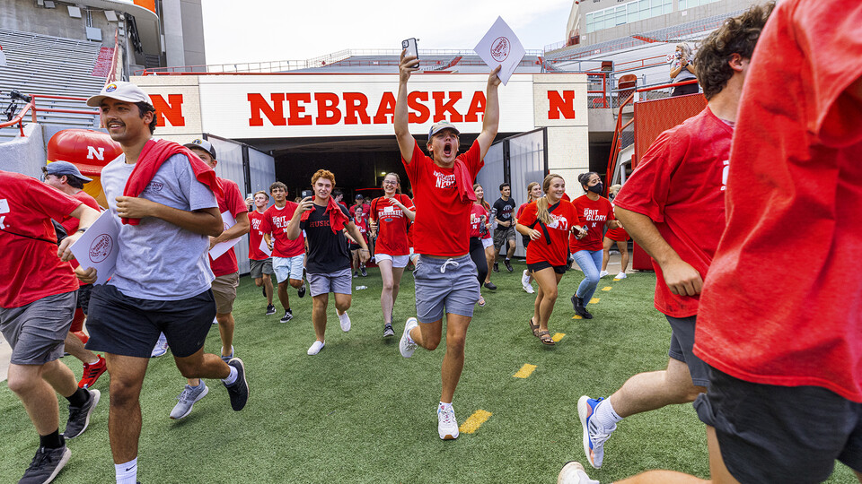 First-year students celebrate as the run onto the field at Memorial Stadium on Aug. 19.