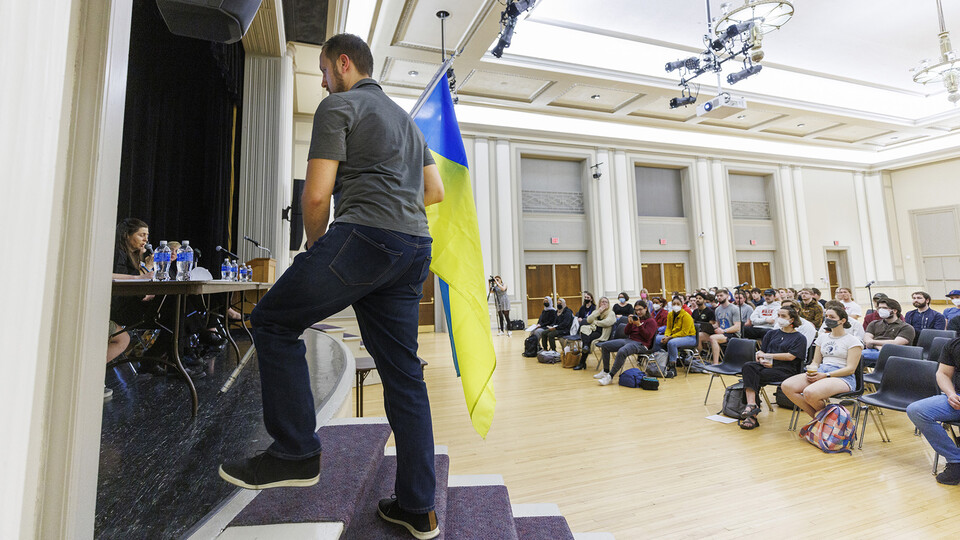 Mykhailo Smyshliaiev, a member of Lincoln’s Ukrainian community, carries the Ukraine flag to the stage before he spoke at the “Stand with Ukraine” event in the Nebraska Union on March 1.