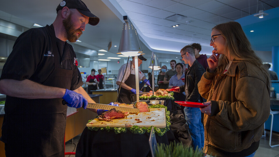 Jake Dietrich (left) serves Grace Clausen at a carving table during the Raikes Beef Co. dinner April 14 at the Cather Dining Center. The event featured hundreds of pounds of beef, all produced some 30 miles east of campus in Ashland.
