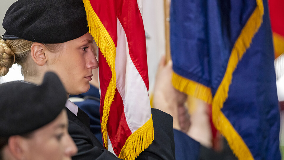 Cadet Sophie Byland holds the flag during the ROTC Joint Service Chancellor’s Review in Cook Pavilion.