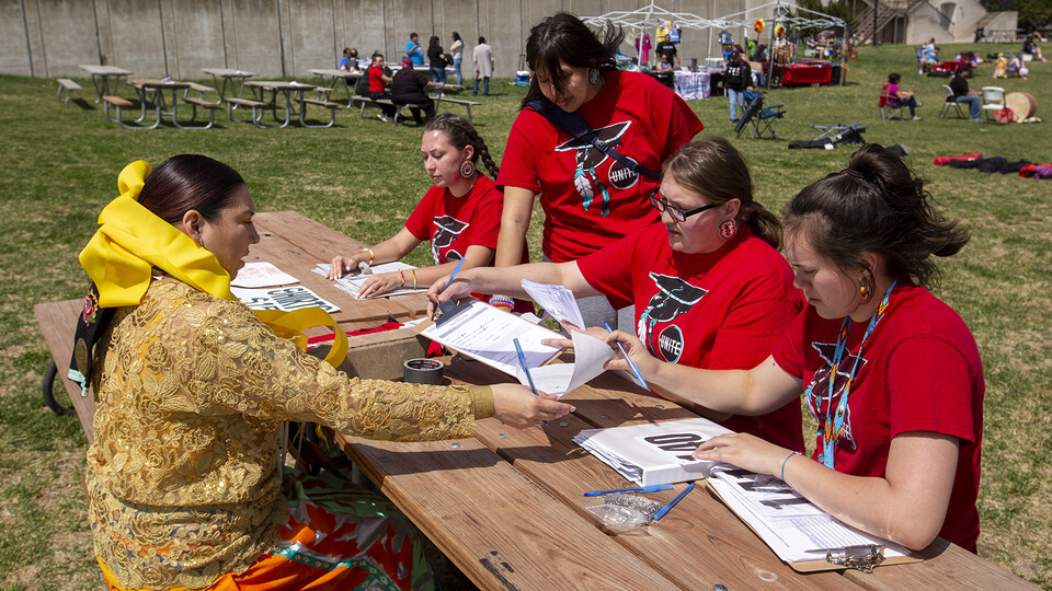 UNITE members accept event registration from Kaira Wolfe, who served as the head woman dancer during the powwow.