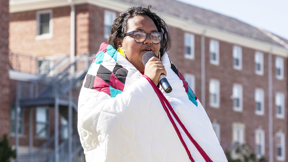 Nasia Olson-Whitefeather talks after being honored as a graduate during the April 23 powwow.