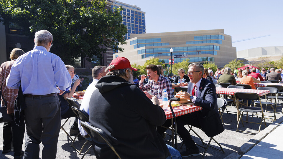University staff and faculty sit with Chancellor Ronnie Green during the employee cook-out on R Street.