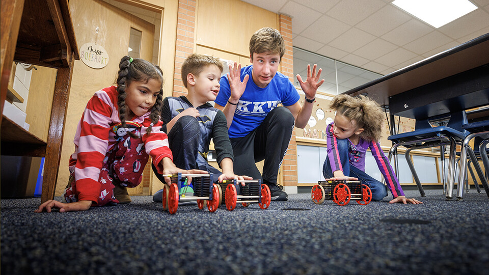 Spencer Knight gets three students and their rubber-band powered cars lined up for a race at Riley Elementary School in Lincoln.