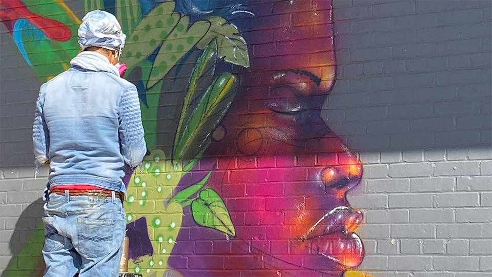 Artist Edir Muniz paints a mural outside The Bay skate park in 2019.