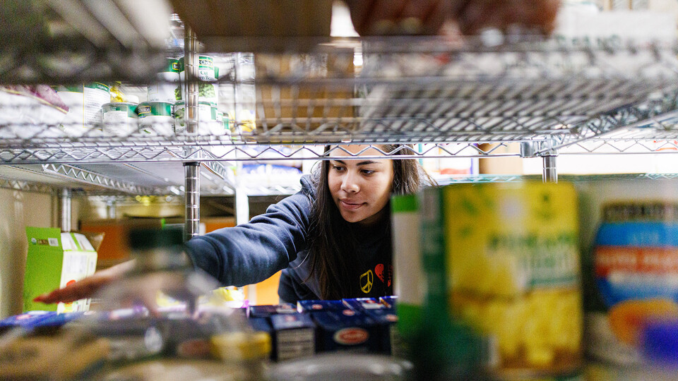 Bree Bell, a freshman from Omaha, sorts food in the store room at Matt Talbot