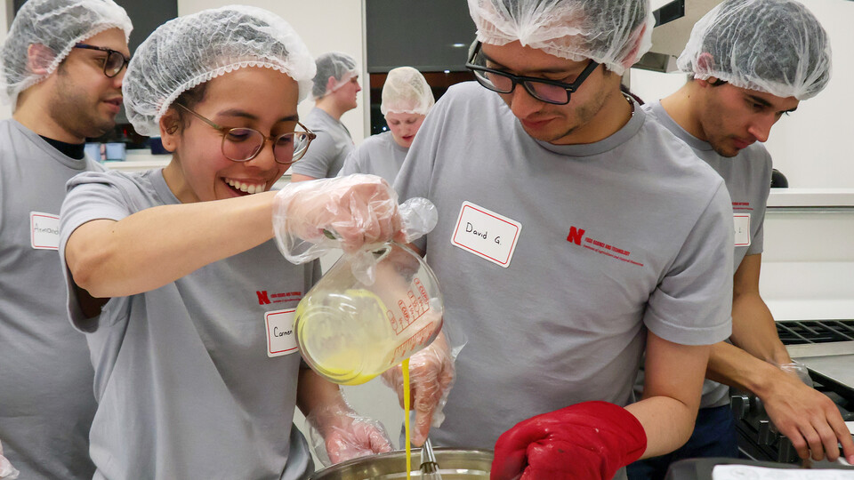 Carmen Perez-Donado pours egg into a mixture as David Fabian Gomez Quintero stirs during the Battle of the Food Scientists Feb. 15 at the Food Innovation Center.