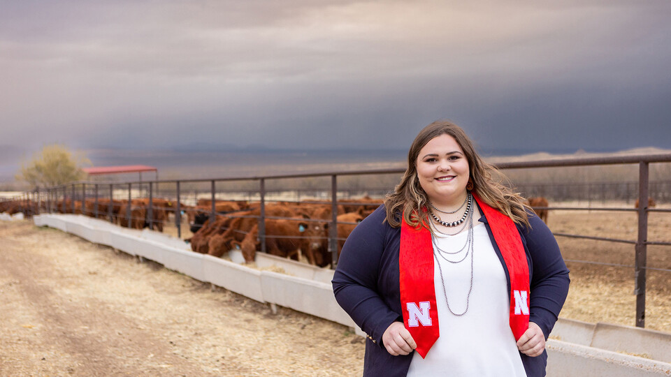 Izzy McGibbon stands ready for graduation during a recent visit to her family's ranch in Arizona. In operation for more than 100 years and owned by the McGibbons for more than 50 years, the Santa Rita Ranch specializes in raising Red Angus cattle.