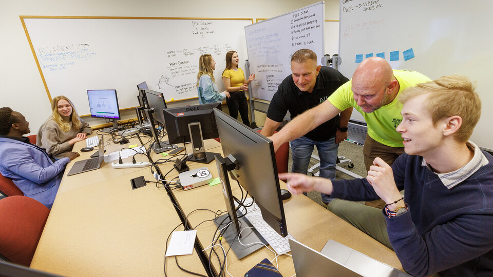 Erik Konnath, right, talks with members of the Allo team, Ed Jarrett and Jon McHenry (in yellow t-shirt) as they discuss the project.  In the background from left are Design Studio team members Samual Rangira, Sophie Hellebusch, Sophie Hill and Hannah Pokharel. May 2, 2023. 