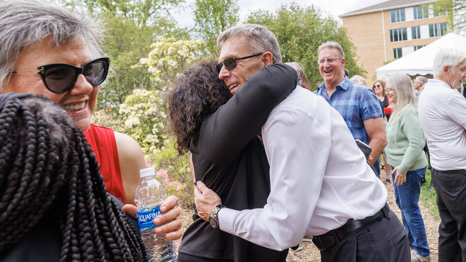 Chancellor Ronnie Green hugs Charlie Foster as Jane Green hugs Reshell Ray in the reception line within Maxwell Arboretum.