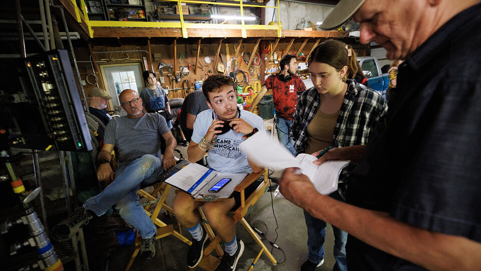 Nebraska student and script supervisor Charlie Major listens to comments by producer Jamie Vesay. At left is Richard Endacott and in the middle right is Grace Birkland, Nebraska student and second assistant cameraperson.