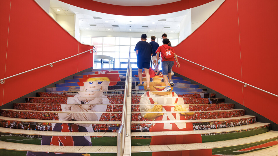 Students walk up the stairs in Nebraska Union Aug 16. The stairs were updated with new decals depicting Herbie Husker and Lil Red.