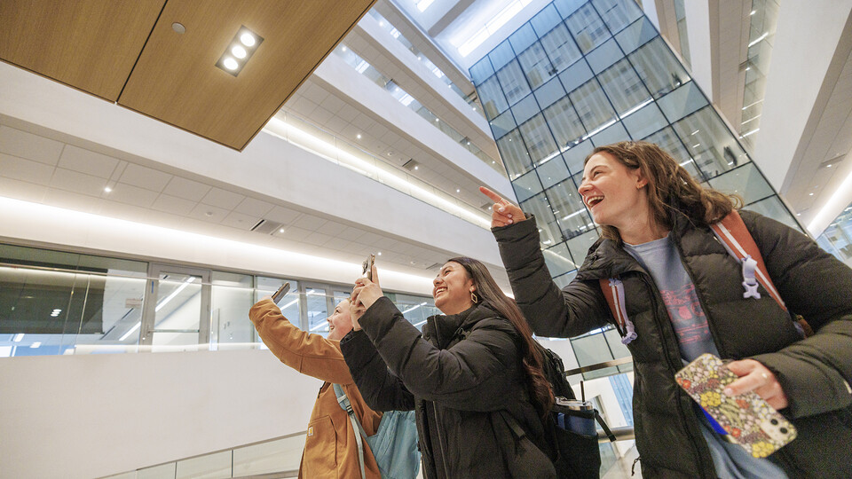 Civil engineering sophomores (from left) Meghan Murphy, Fatima Pilar-Solis and Miriam Huss photograph friends as they go to their first class in Kiewit Hall on Jan. 22.