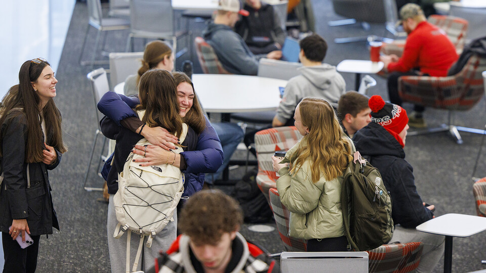 Anna Schuppel gives Riley Einspahr a hug as the friends meet in the East Commons of Kiewit Hall.