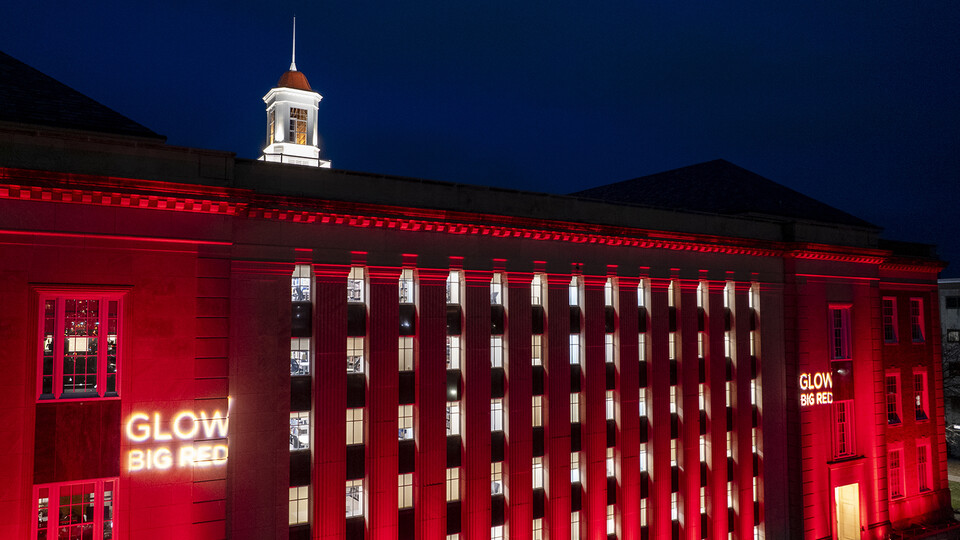 Red lights light up the south facade of Love Library.