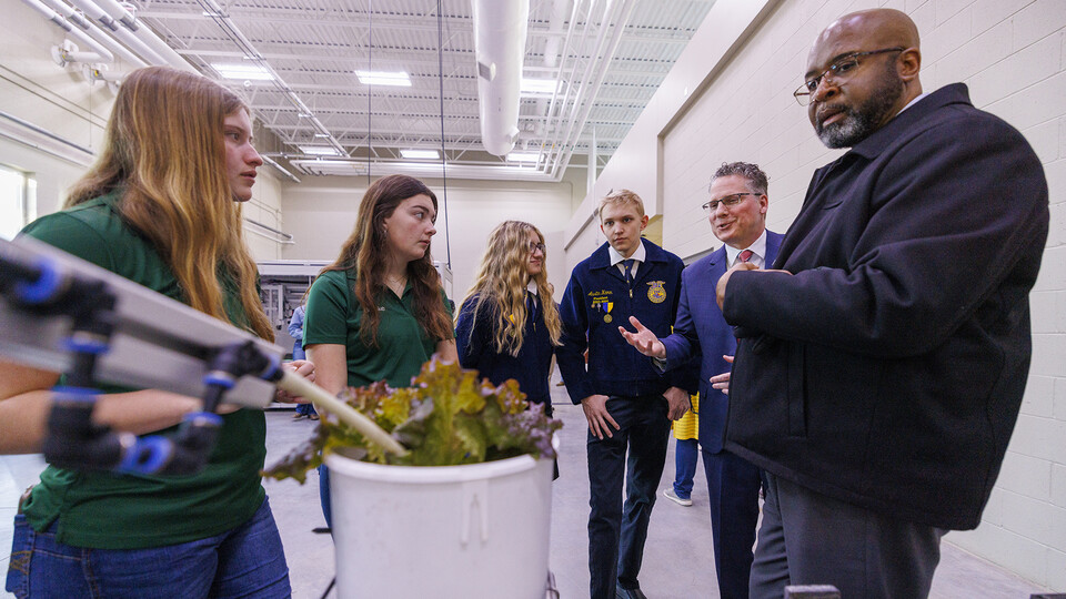 Cassidy Marickle and Brook Brengelman, seniors from Boone Central High School, Johanna Roux and Austin Kamm, seniors from Lincoln Southwest, listen as Derek McLean, dean of the Agricultural Research Division and Chancellor Rodney D. Bennett explain the phenotyping facility at Nebraska Innovation Greenhouse.