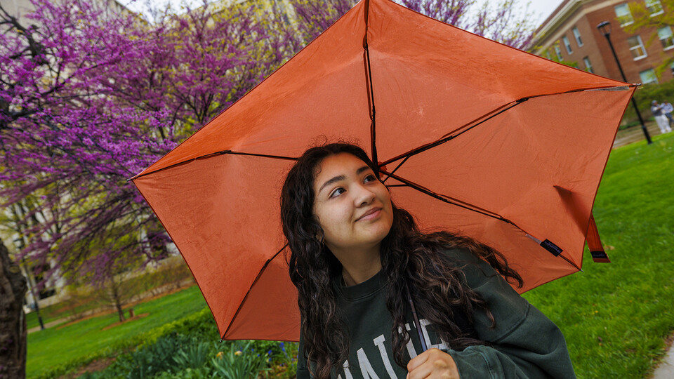 Jessica Meza, a sophomore in journalism and advertising and public relations, glances at the flowering trees while walking across campus.
