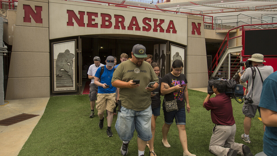 Aaron Shester (front left) and his children lead the Pokémon Go players into Memorial Stadium. The Shesters were the first in line at the event, arriving an hour ahead of the 4 p.m. start time.
