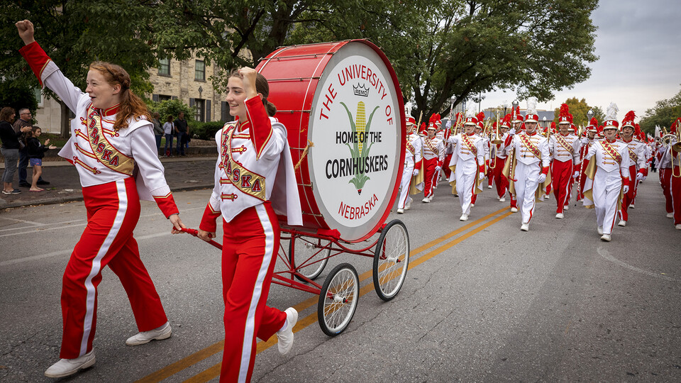 Members of the Cornhusker Marching Band walk with the five-foot-tall "Big Bertha" drum during the 2021 homecoming parade. The drum was recently refurbished through the Nebraska Alumni Association.