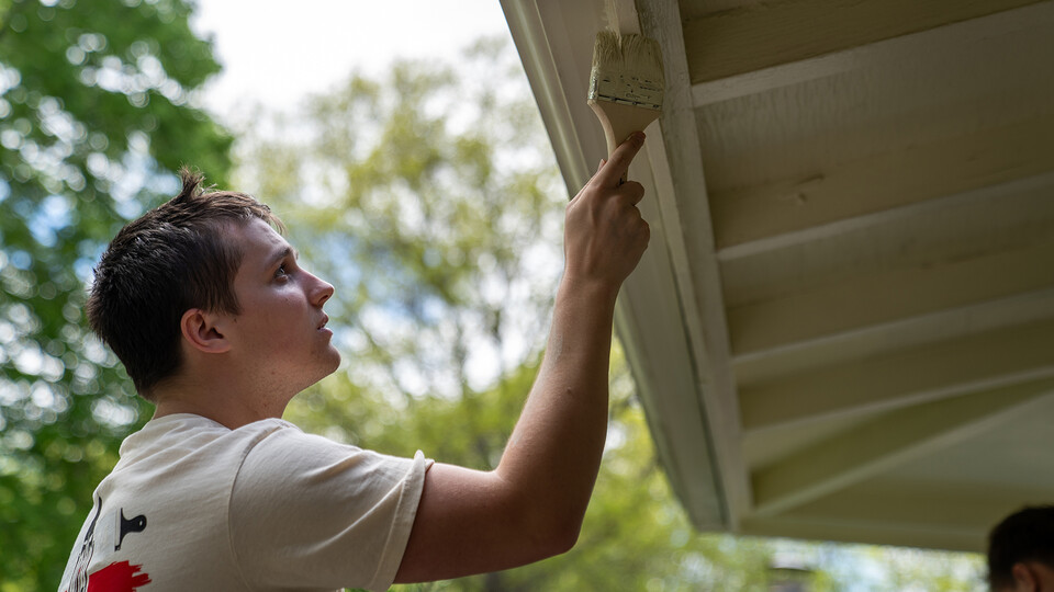 Pi Kappa Alpha’s Cole Geer, a member of Pi Kappa Alpha, paints the exterior of a garage during the Big Event on May 4. The community service event, which completed its 18th year at the University of Nebraska–Lincoln, included hundreds of students helping at sites across Lincoln.