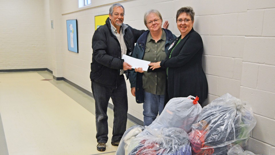 Dennis Ferraro (from left) and Dee Ebbeka, members of the School of Natural Resources' community engagement committee, present Clare Nelson with donations after the 2014 drive. 