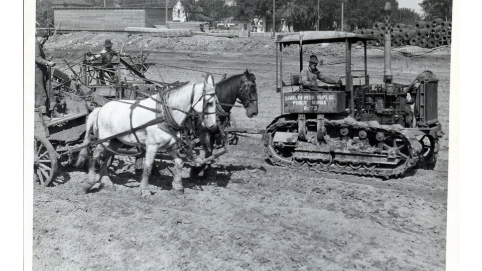 A horse-drawn plow and bulldozers move earth at the future site of Memorial Stadium