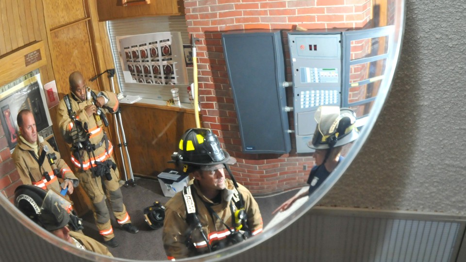 Lincoln firefighters are reflected in a Pound Hall mirror during a training session in 2013. UNL has launched an initiative to develop individual building plans for emergency situations.