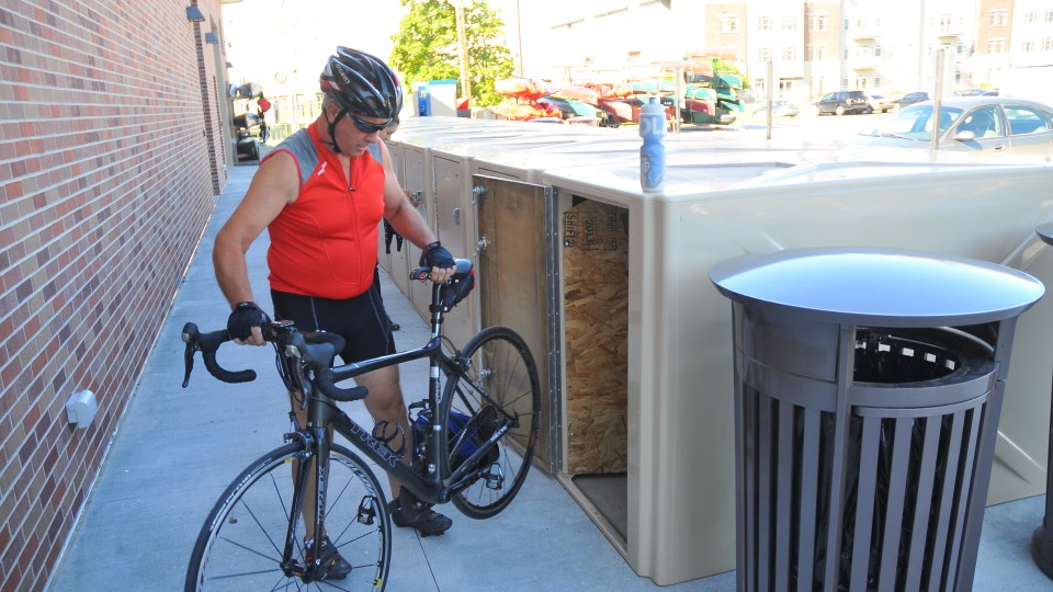 Craig Munier removes his bike from the storage lockers outside UNL's new Outdoor Adventures Center. The center includes UNL's first dedicated bike commuter facility.