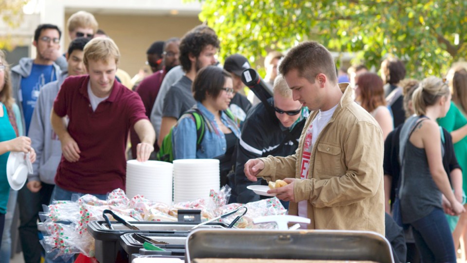 Students in UNL's fine and performing arts and architecture colleges stand in line for free food during the Oct. 24 tailgate outside Kimball Hall. The event was held as part of the proposed consolidation of the two colleges.
