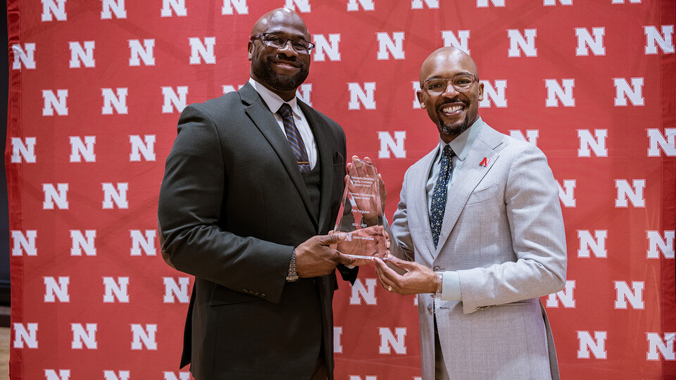 Peter Ferguson accepts the Diversity Community Impact award from Marco Barker, vice chancellor of diversity and inclusion.