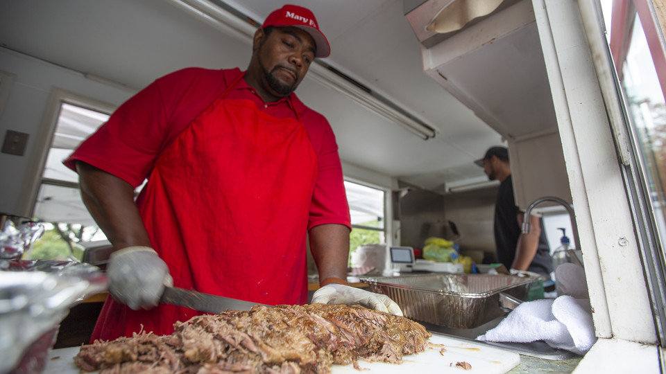 Charles Phillips slices brisket in his food truck, Mary Ellen's Food for the Soul. The truck was one of two available on the Nebraska Union plaza on Aug. 20.