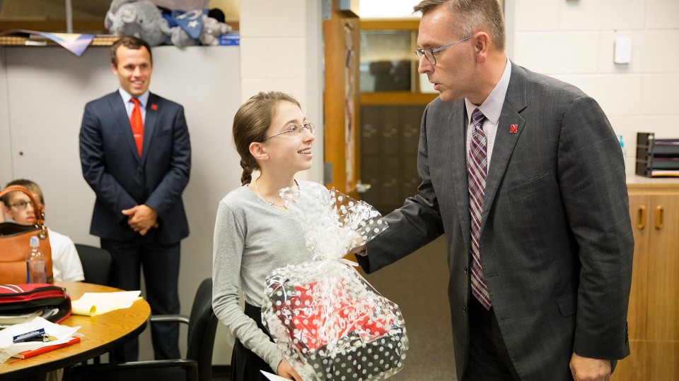 Chancellor Ronnie Green presents a scholarship to eighth grader Ava Steele, 13, at Westside Middle School in Omaha on Sept. 27. Steele is one of three Nebraska middle school students who earned perfect scores on a section of the ACT and recently received full-tuition scholarships to attend the University of Nebraska–Lincoln.