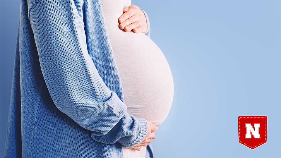 Pregnant woman cradling her belly with her arms