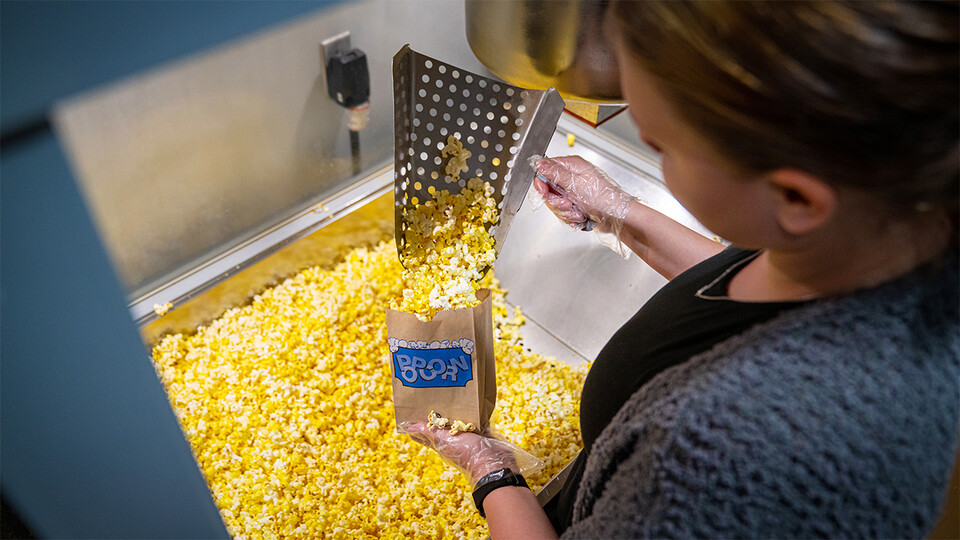 Employee scooping popcorn at The Ross