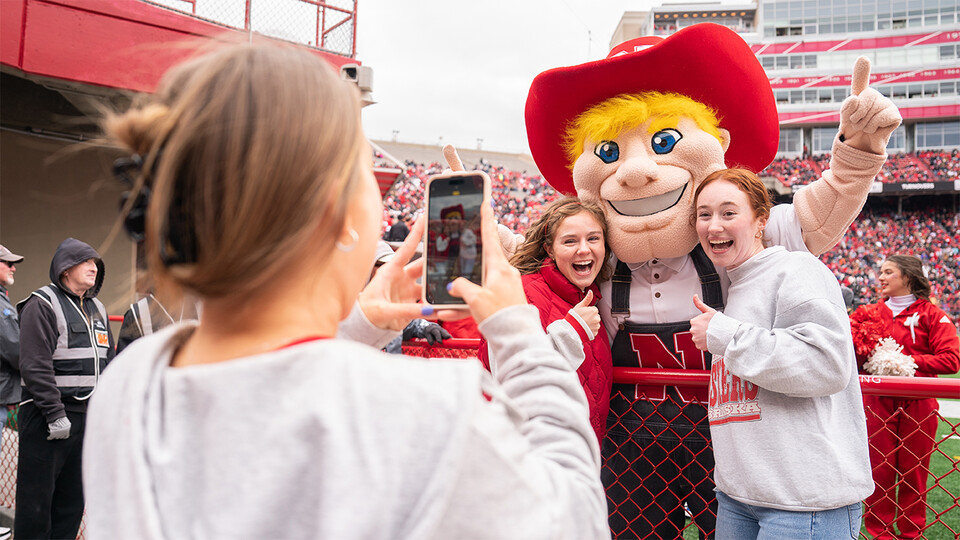 Students posing with Herbie Husker