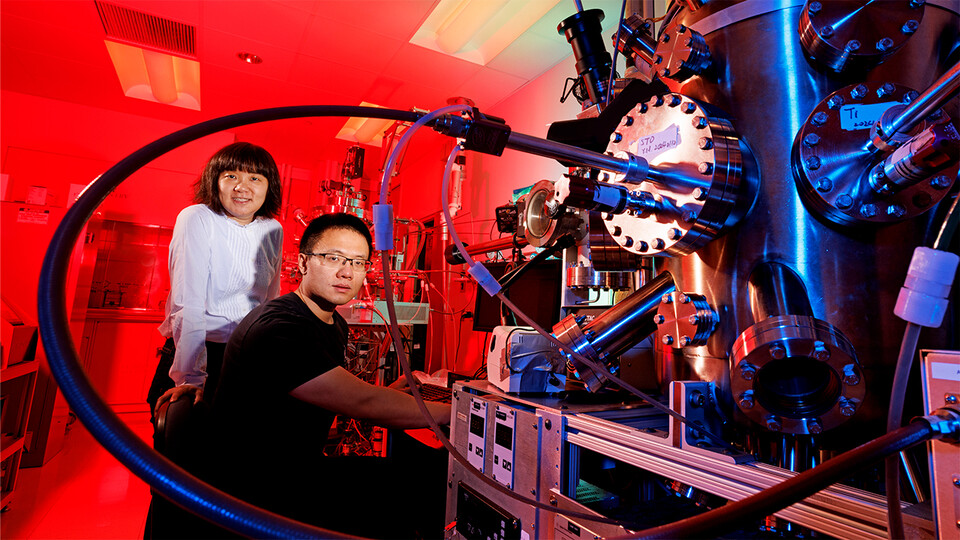Xia Hong and Yifei Hao next to a computer and pressure vessel in Jorgensen Hall