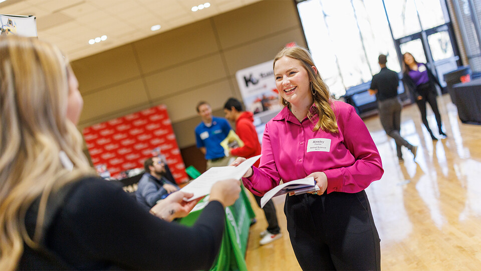 Ainsley Fischer speaks with a recruiter at a career fair