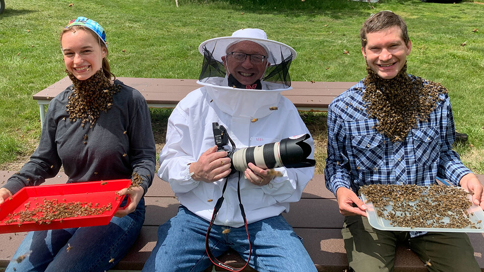 Craig Chandler (center) poses with students during a bee beard photo shoot on East Campus. Chandler recently earned a national award for a photo from the shoot.