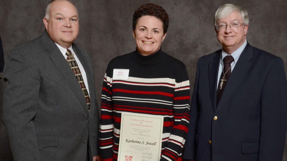 Katie Jewell (center), associate director of academic programs for athletics, accepts her Parents Association award from (left) Bryan Reiling, chair of the UNL Teaching Council and Timothy Draftz, co-president of the UNL Parents Association.