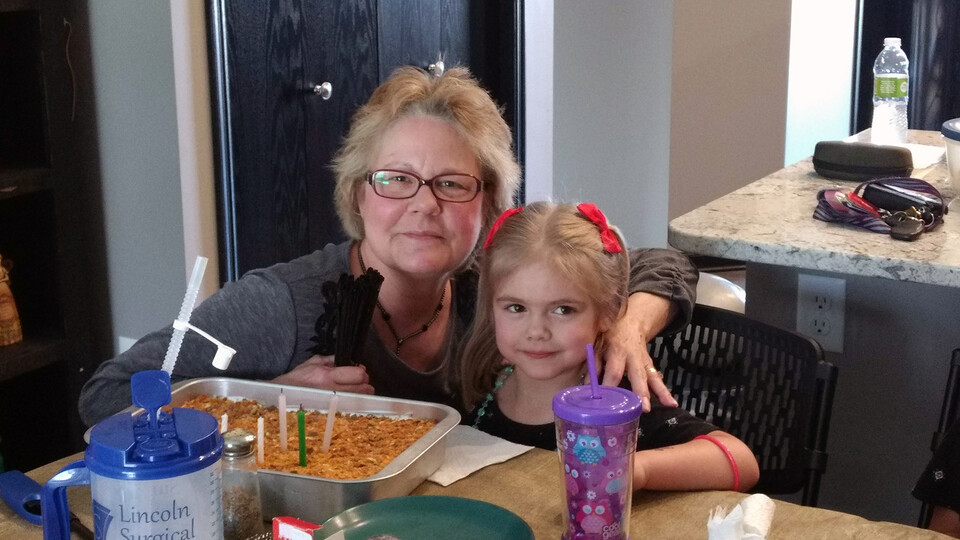 Wendy Kempcke poses with her granddaughter during a birthday party. Kempcke has worked for nearly 23 years with the Nebraska Alumni Association. She will retire in March.