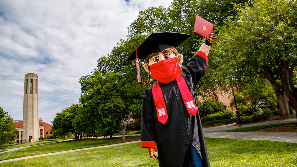Herbie Husker celebrates graduation on the green space south of Mueller Tower.