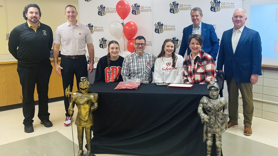 Lillias McKillip celebrated her signing on as UNL's second Presidential Scholar with (from left) her sister, Bea; parents, Austin and Jessica; Tanner Penrod, principal, Southeast High School; Gov. Jim Pillen; Chris Kabourek, interim NU president; and Tim Clare, regent, of Lincoln.