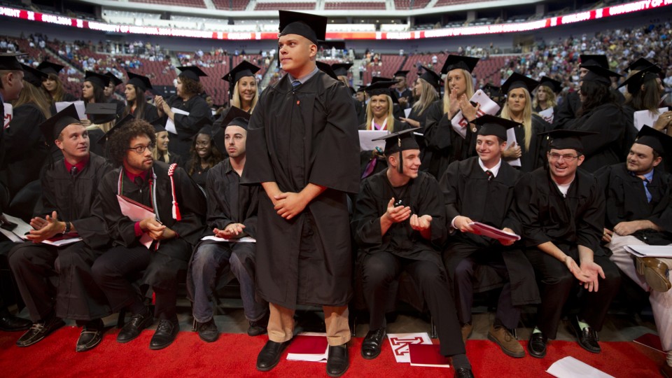 Students receiving military commissions stand to be recognized while others rise to cheer during the All-University Commencement at Pinnacle Bank Arena on Aug. 16.