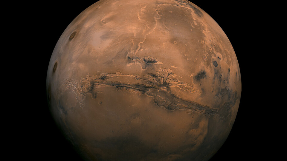 Mosaic of the Valles Marineris hemisphere of Mars projected into point perspective, a view similar to that which one would see from a spacecraft. The mosaic is composed of 102 Viking Orbiter images of Mars.