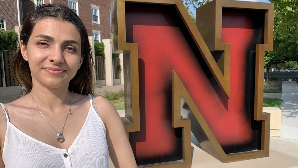 Photo of Nasrin Nawa standing in front of the Nebraska "N" sculpture at the Wick Alumni Center.
